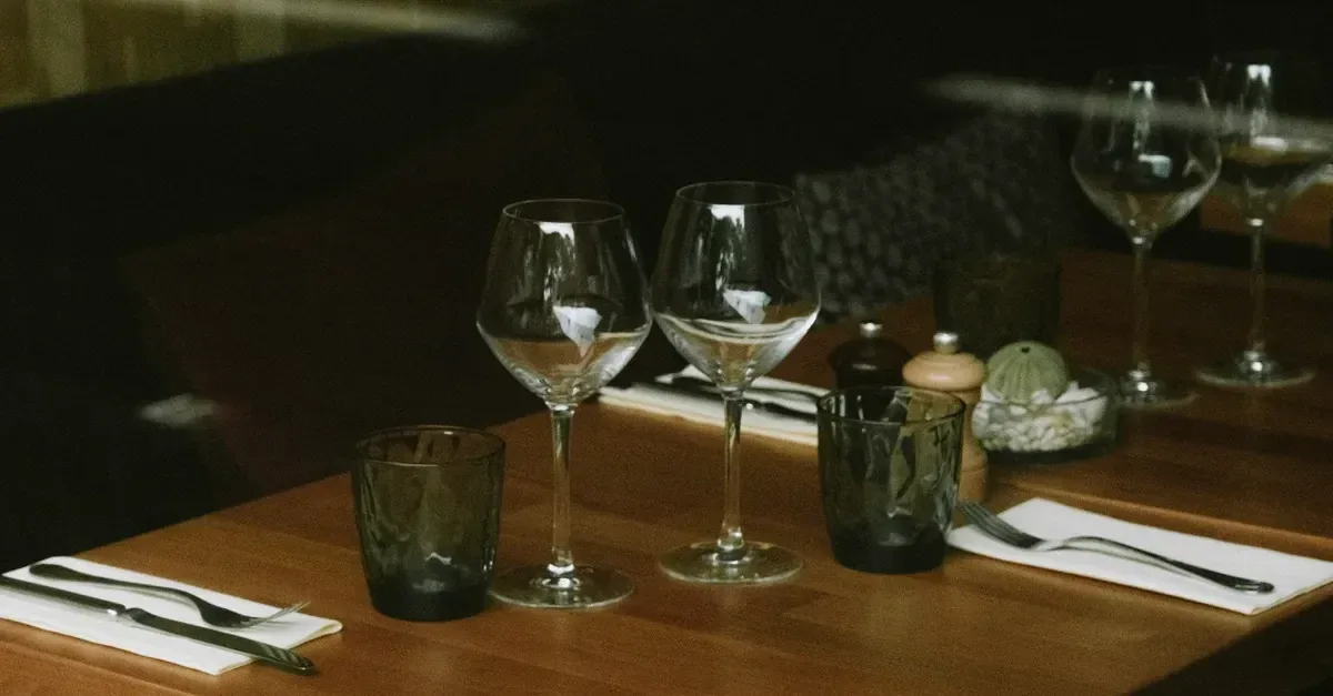 Verfijnd diner met signatuurcocktails in gerookt glas, warme barverlichting, donkere houttinten en een rustige luxe sfeer